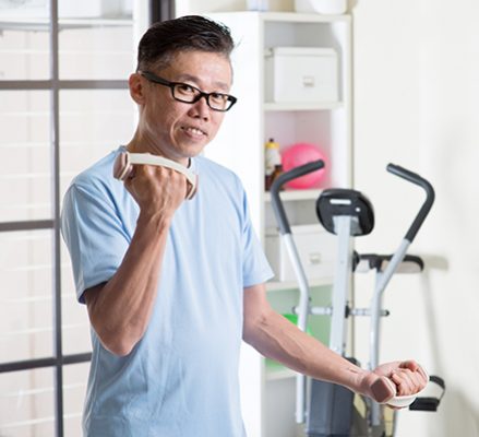Mature Asian man with dumbbells at gym กิจกรรมเสริมสำหรับผู้ป่วยหลังผ่าตัด บ้านลลิสา