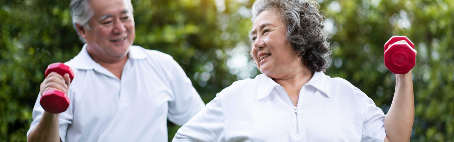 Asian Senior Couple exercising with red dumbbells at the outdoor เรียนรู้วิธีส่งเสริมคุณภาพชีวิตของผู้สูงอายุที่สามารถนำไปปรับใช้ได้จริงสำหรับคนในครอบครัว